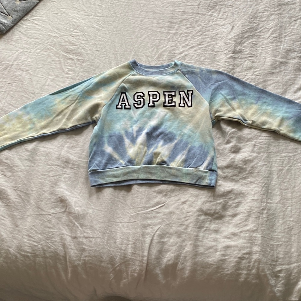Tie dye jumper with the name “Aspen” in it.
